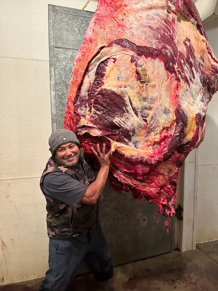 Hyndman butcher standing beside a locally processed beef carcass